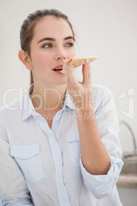 Pretty brunette eating slice of pizza