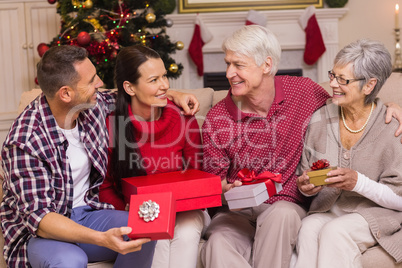 Smiling family holding present on sofa