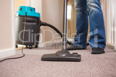 Close up a young man vacuuming