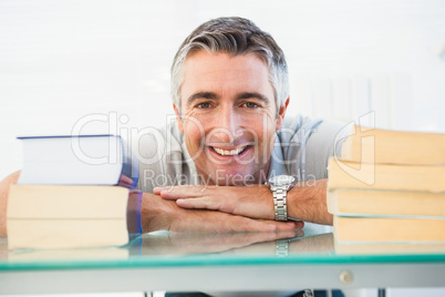 Happy man posing between books