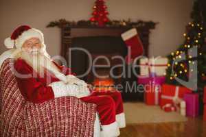 Festive santa claus sitting on couch at christmas