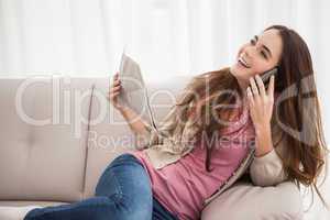 Pretty brunette on the phone holding newspaper