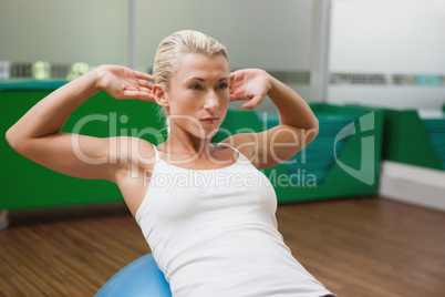 Beautiful woman doing abdominal crunches on fitness ball