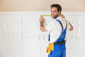 Handyman measuring a wardrobe