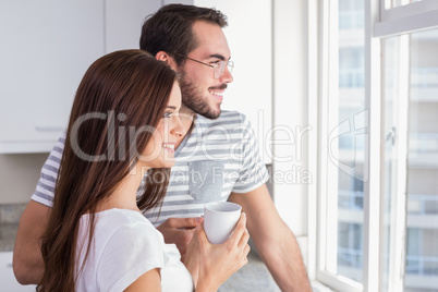 Young couple looking out their window