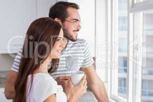 Young couple looking out their window