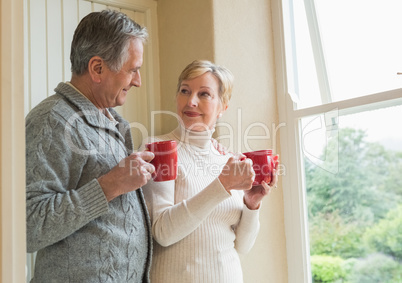 Senior couple holding red mugs