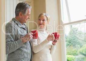Senior couple holding red mugs
