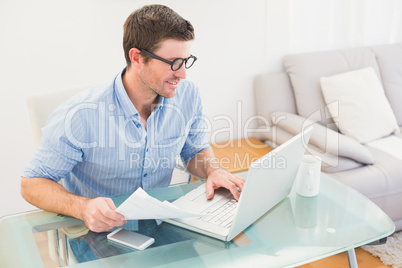 Smiling businessman using his laptop at desk