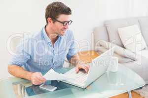 Smiling businessman using his laptop at desk