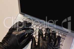 Close up of burglar hacking a laptop