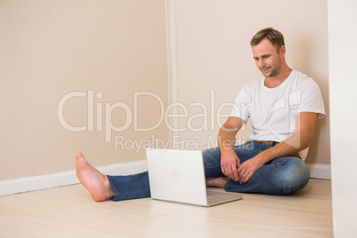 Happy man using laptop after moving in