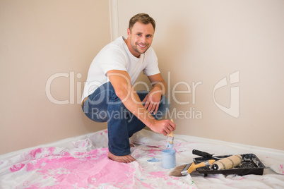 Man using paintbrush to paint wall blue