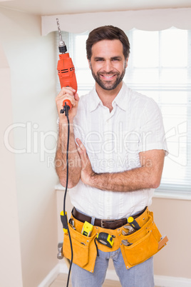 Handyman smiling at camera holding drill