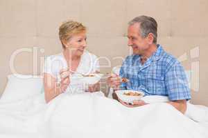 Senior couple having breakfast in bed