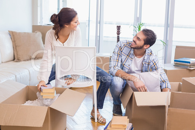 Cute couple unpacking cardboard boxes