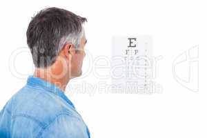 Man with grey hair doing a eye test