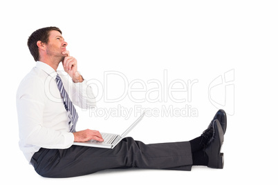 Businessman using laptop and thinking