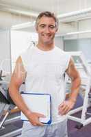Fit personal trainer smiling at camera in fitness studio