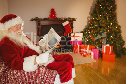 Santa claus reading newspaper on the couch