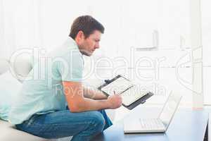 focused man on a laptop with a notebook