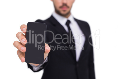 Businessman showing smartphone to camera