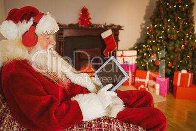 Santa listening music and touching tablet