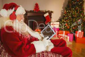 Santa listening music and touching tablet