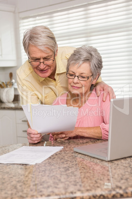 Senior couple paying their bills with laptop