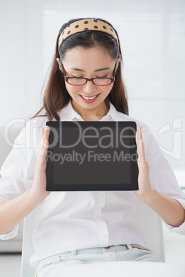 Businesswoman sitting and showing tablet