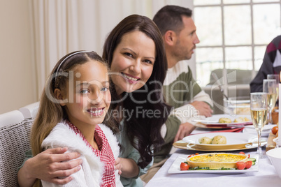 Girl and mother at christmas dinner smiling at camera