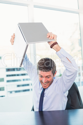 Angry businessman throwing his laptop