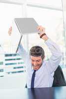 Angry businessman throwing his laptop