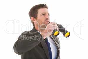 Focused handsome businessman holding binoculars
