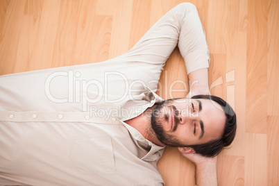 Young man lying on floor thinking