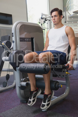 Fit man using weights machine for legs