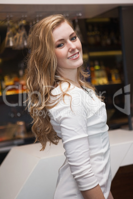 Smiling blonde girl in white dress posing