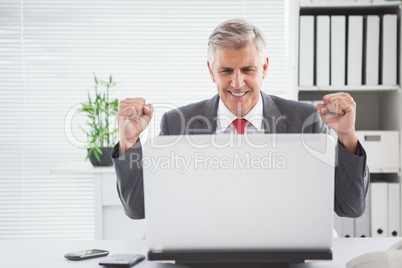 Cheering businessman at his desk