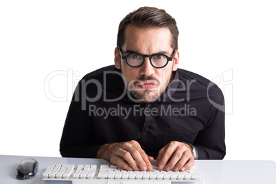 Concentrated businessman with glasses typing on keyboard