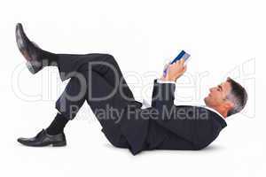 Relaxed businessman lying and reading book