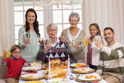 Happy extended family at christmas toasting at camera