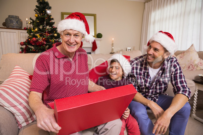 Smiling grandfather opening his gift