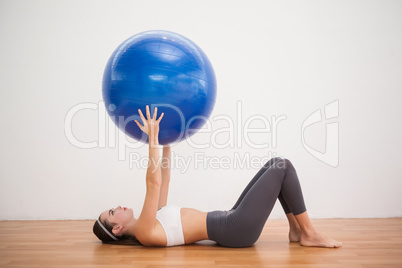 Fit brunette working out with exercise ball