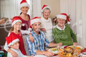 Happy extended family in santa hat looking at camera