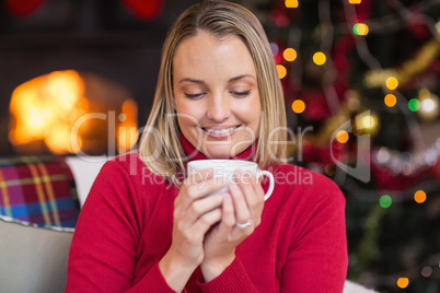 Pretty blonde enjoying a hot drink at christmas