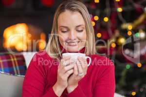 Pretty blonde enjoying a hot drink at christmas