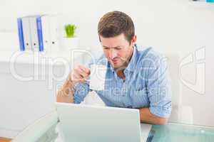 A businessman holding mug at desk