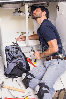 Plumber fixing under the sink