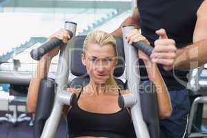 Fit woman using fitness machine at gym