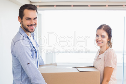 Cute couple carrying cardboard box